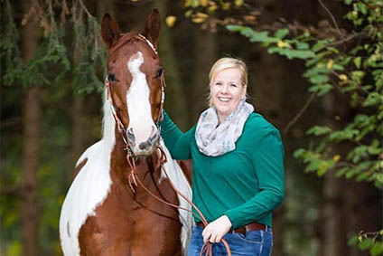 Verena Gößler zusammen mit ihrem Pferd am Walsrand